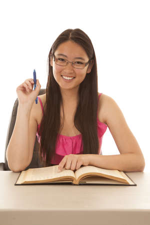 A woman with a smile on her face studying her book.の写真素材