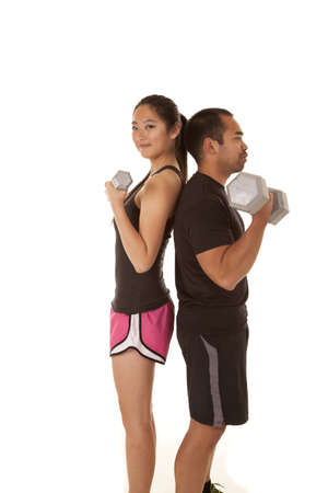 A man and a woman working out with weights back to backの写真素材