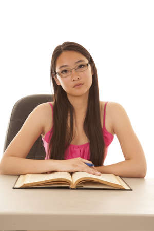 a woman with a sad expression on her face with her book open and pen in her hand.の写真素材