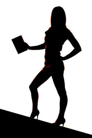 A silhouette of a woman holding on to one book.の写真素材