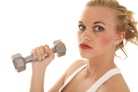 A close up of a woman holding on to a weight with a serious expression