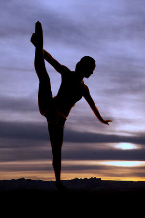 a woman pulling her leg up showing off her flexability.の写真素材
