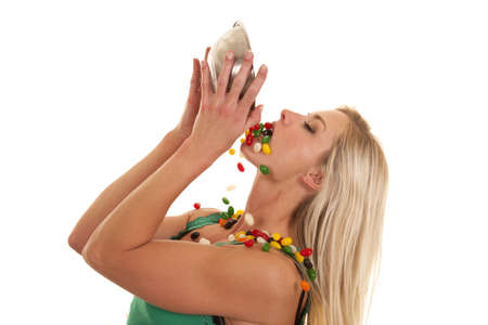 A woman pouring a bowl of jelly beans all over herの写真素材