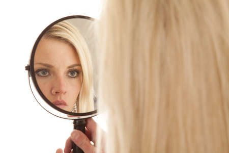 A woman is looking into a mirror up closeの写真素材