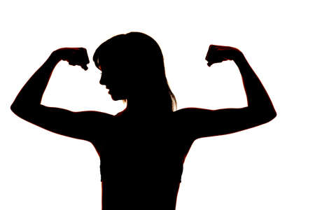 A woman silhouette flexing her arms.の写真素材