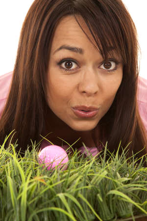 A close up of a woman trying to blow her golf ball in, in the deep tall grass.の写真素材