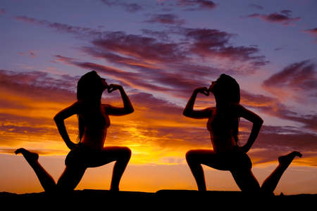 A silhouette of a woman with her hand by her chin posing.の写真素材