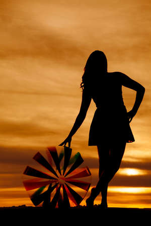 a silhouette of a woma standing next to her beach ball.の写真素材