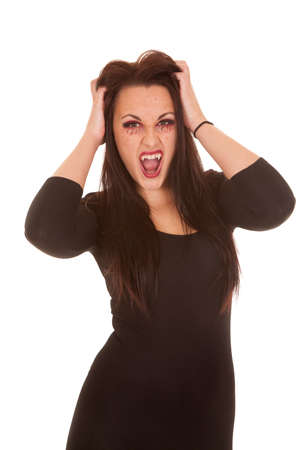 A woman vampire with her hands in her hair with her mouth open.の写真素材