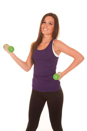A woman is smiling and curling a weight.の写真素材