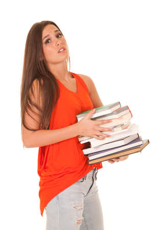 A woman is stressed holding a stack of books.の写真素材