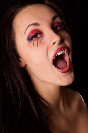 A close up of a vampire woman showing off her fangsの写真素材