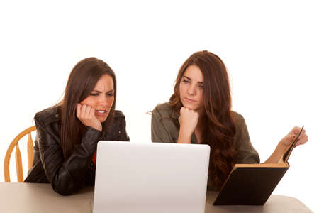 Two women are looking at a computer frustrated.