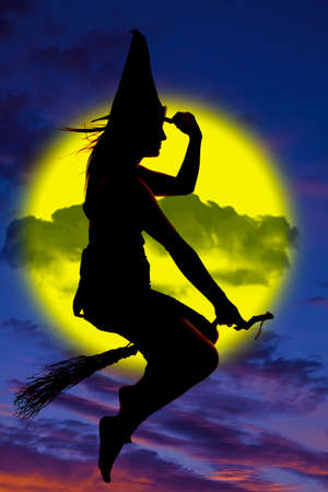 A silhouette of a witch flying on her broom.の写真素材
