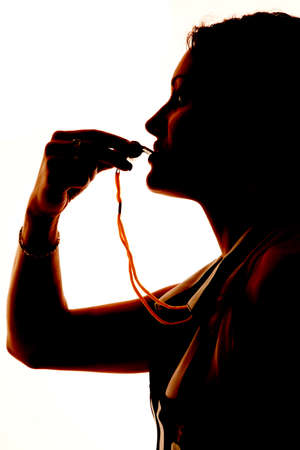 A close up silhouette of a female referee with her whistle.の写真素材
