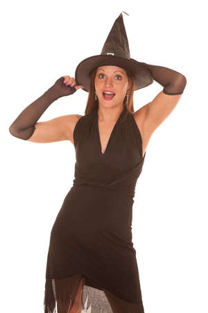 A witch is holding her hat on her head and her mouth is open.の写真素材