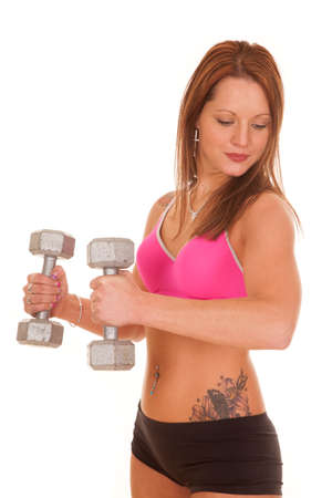 A woman is curling weights while looking down.の写真素材