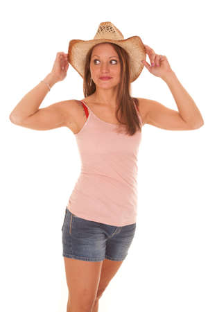 A woman is holding her cowboy hat on her head.の写真素材