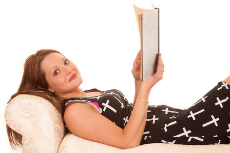 A woman is laying down with a book.の写真素材