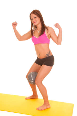 A woman is flexing while holding a ball between her legs.の写真素材