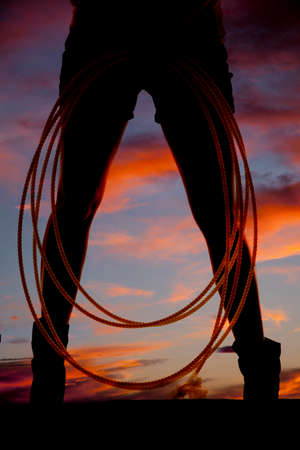 A silhouette of a woman with her rope by her legsの写真素材