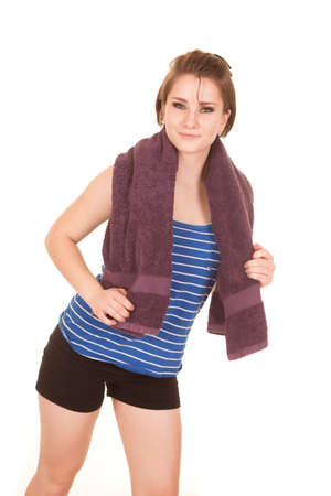 a woman after a workout holding on to her towel with a small smile on her face.の写真素材