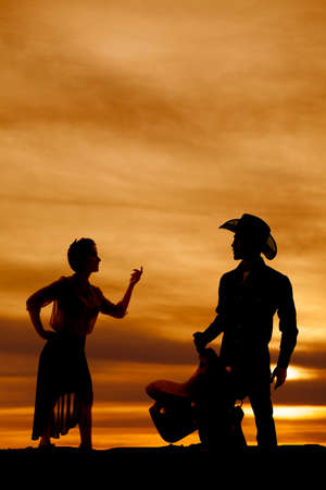 a silhouette of a woman telling her man to come here.の写真素材