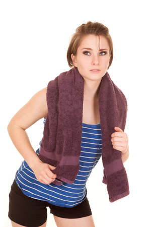 a woman after a workout holding on to her towel with a serious expression on her face.の写真素材