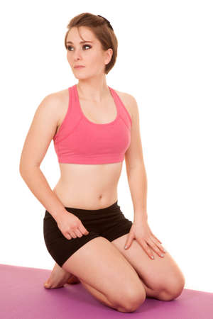 A woman in her fitness clothing kneeling on her workout mat.の写真素材