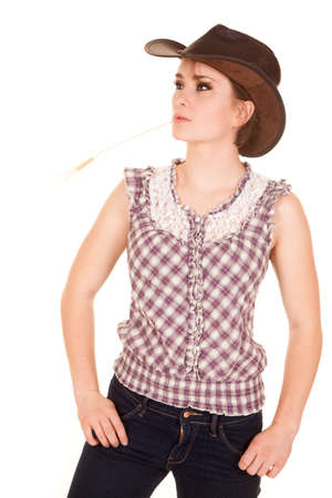 A woman in her western wear with a piece of wheat in her mouth.の写真素材