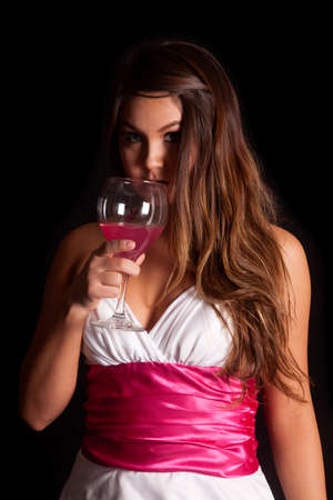 A woman is holding a wine glass close to her face.の写真素材
