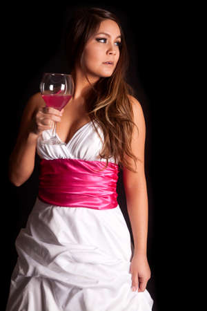 A woman is holding a wine glass looking to the side.の写真素材