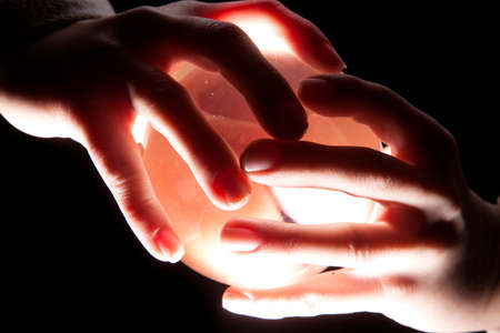a lighted ball in a persons hands.