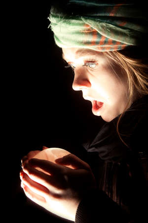 a gypsy looking at her crystal ball with a shocked expression.の写真素材