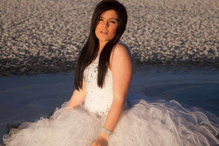 a woman with a serious expression in her formal dress standing outside on a frozen lake.の写真素材