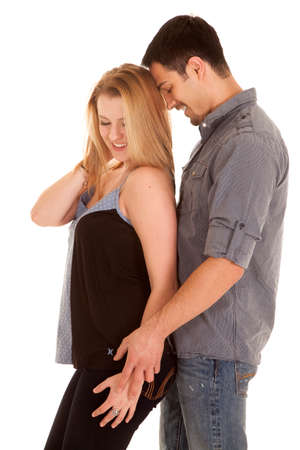 A woman is standing in front of a man who is holding her hand.の写真素材