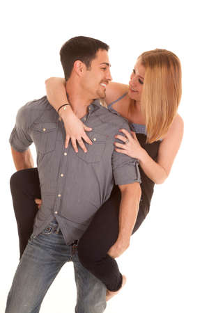 A man is holding a woman on his back and they are smiling.の写真素材