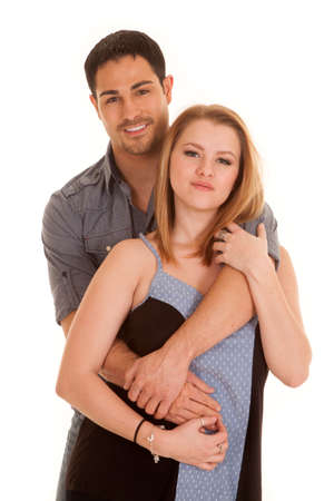 A couple is standing with happy expressions and the man is behind her.の写真素材