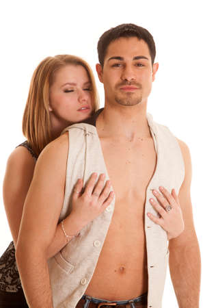 A man with an open vest is in front of a woman with her eyes closed.の写真素材
