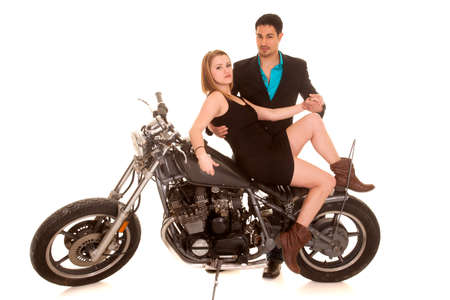 A couple on a motorcycle sitting holding each other.の写真素材