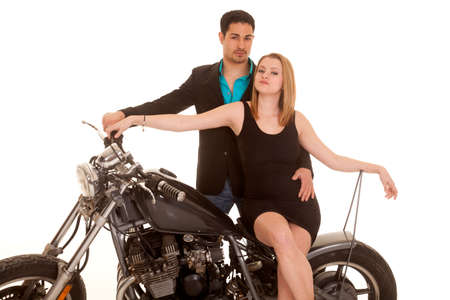 a man standing behind his woman on a motorcycle.の写真素材