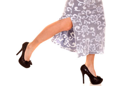 Legs of a woman in a dress running to the side in heels.の写真素材
