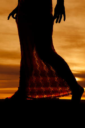 Silhouette of legs of a woman in a lace skirt.の写真素材