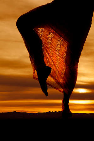 Silhouette of legs of a woman in a lace skirt.の写真素材