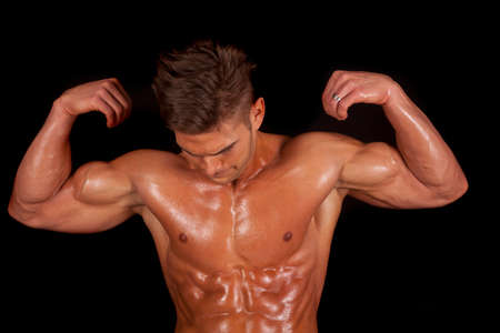 a man looking down at his body as it is sweating.の写真素材