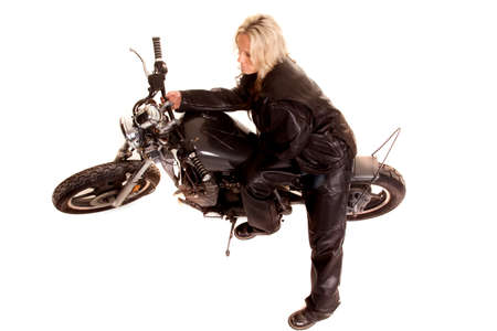 A woman sitting on a motorcycle in leather.の写真素材