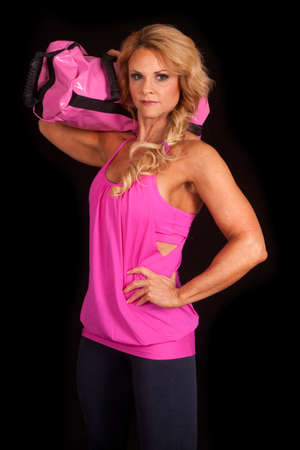 A woman in a pink tank top with a bag on her shoulder.の写真素材