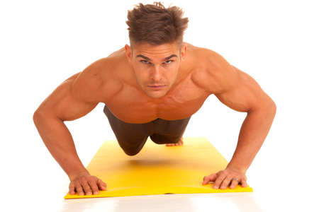 A man working out doing a push up on a fitness mat.