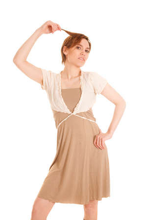 A woman in her dress pulling on a strand of her hair serious.の写真素材