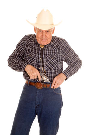An elderly man puts a pistol in his pants.の写真素材
